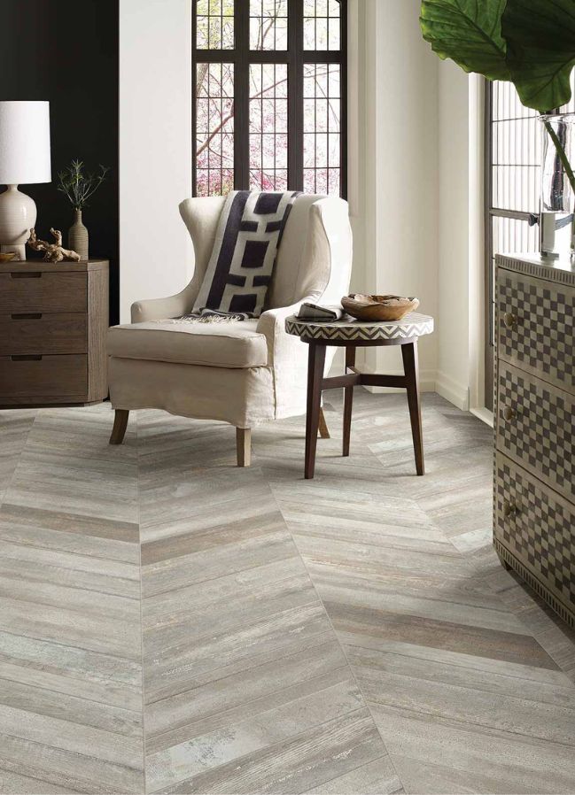 wood look tile floors in a stylish living room with upholstered chair and corner windows